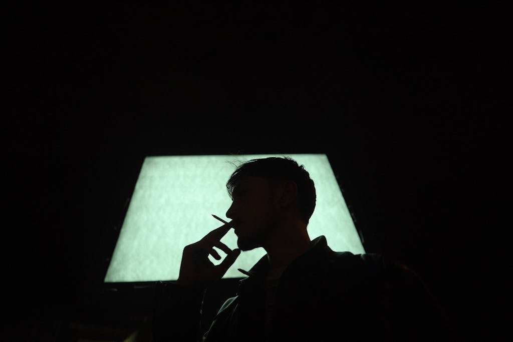 Silhouette of a Man Smoking a Cigarette